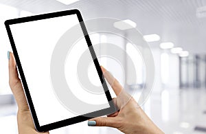 Tablet mockup in woman hand with business centre background. Modern tablet computer mock up with blank white screen. Empty space f