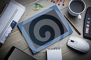 Tablet next to the cup of coffe notepad computer and smartphone