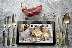 Tablet with Online food delivery app on screen. lifestyle concept