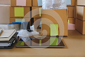 tablet, packing accessories at workplace of startup small business owner. cardboard parcel box for online selling.