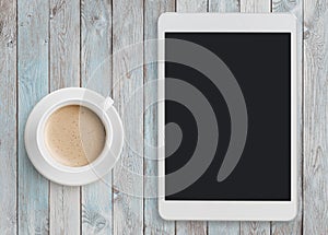 Tablet pc looking like ipad on table with coffee cup