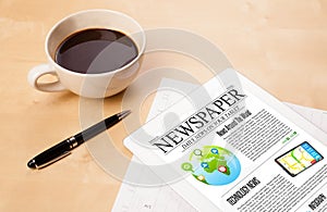 Tablet pc shows news on screen with a cup of coffee on a desk