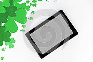 Tablet pc and st patricks day decorations on white