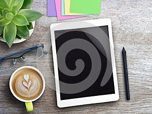Tablet,pen mouse,sticky notes and coffee with flower on wood table background