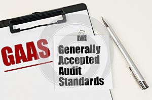 On the tablet, a sheet of paper and stickers with the inscription - GAAS, Generally Accepted Audit Standards