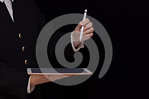 Tablet and stylus in female hands on black background, online business, e-commerce, digital design background