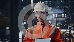 Tablet supervisor checking factory manufacturing facility making notes close up.