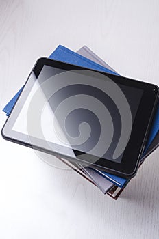 Tablet on top of books.Concept of e-learning, distance training and reading online
