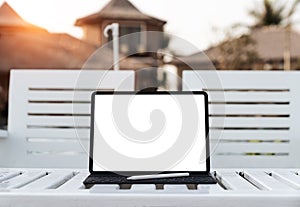 Tablet white screen on table at sunset