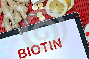 Tablet with word Biotin. Healthy eating. photo
