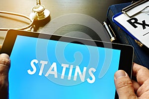 Tablet with word statins. photo