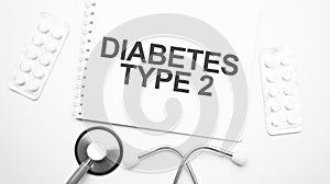 On the tablet for writing the text diabetes TYPE 2, next to the stethoscope and white tablets