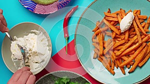 Tabletop food video recipes: man adds cottage cheese to the crispy sweet potatoe fries, cooking yams 4k