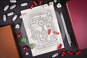 Tabletop role playing flat lay with RPG game dices, hand drawn dungeon map, rule books and pen