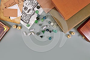 Tabletop roleplaying flat lay with RPG and game dices, rule book, notes and treasuremap on gray background with copy space photo