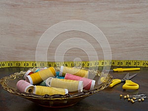 Tabletop with sewing materials in yellow. Copyspace on the light background.