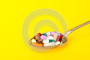 Tablets, capsules, pills in spoon on bright background. The concept of medicine and health