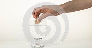 Tablets Falling into a Glass against White Background