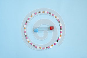 Tablets in the form of a circle inside a test tube for taking a blood sample on a blue background.