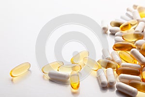 Tablets, pills, capsules, drugs pouring out of white bottle on white background. Sport, healthy lifestyle, medicine