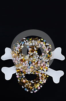 Tablets, pills and capsules, that shape a creepy skull., isolated on black background with copy space.
