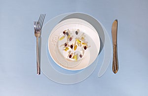 Tablets, pills and capsules on a white porcelain plate. The table is set with a plate