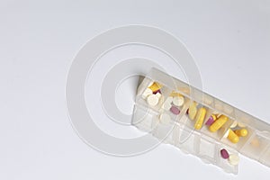 Tablets and pills are spread out into a container for tablets on the days of the week.