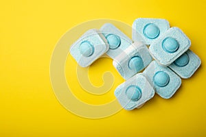 Tablets for softening water on a yellow background.