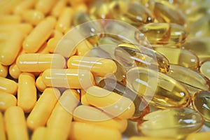 Tablets, yellow capsules on natural background with selective focus.