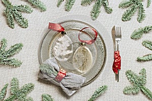 Tableware for Christmas or Xmas festive dinner, linen napkin on plate, red wine glass, bottle of wine on rustic