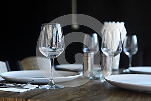 Tableware, glass and plates with napkins at restaurant table