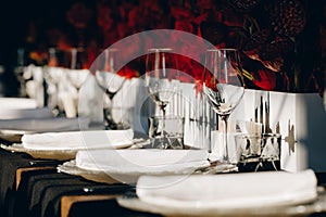 Tableware Glasses, flower fork, knife served for dinner in restaurant with cozy interior