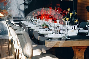 Tableware Glasses, flower fork, knife served for dinner in restaurant with cozy interior