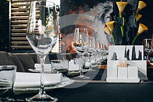 Tableware Glasses, flower fork, knife served for dinner in restaurant with cozy interior