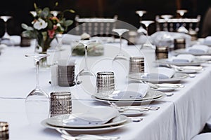 Tableware Glasses, flower fork, knife served for dinner in restaurant with cozy interior