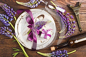 Tableware with violet lupinus and silverware