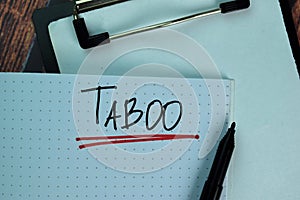 Taboo write on a book isolated on Wooden Table