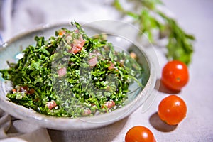 Taboule or tabbouleh salad with tomato, onion and cucumber served in dish isolated on food table top view of middle east spices