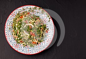 Tabule - oriental salad, appetizer on a black background copy space photo