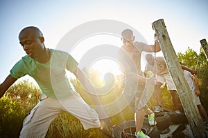 Tackling the obstacle course with determination. a group of young men going through an obstacle course at bootcamp.