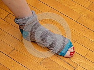 Tacky torn apart sock with foot toes peeking out