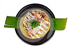 Taco condesa with fried fish on black plate isolated on white background top view photo