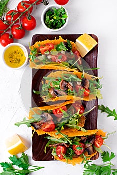 Tacos with cheese shells, roasted mushrooms, cherry tomatoes and arugula. Vegetarian gluten free