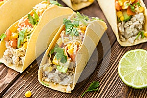 Tacos with lime, corn, chicken, tomato, avocado, cheese and parsley