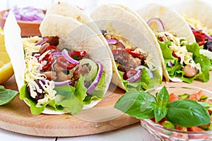 Tacos is a traditional Mexican dish. Tortilla stuffed with chicken, bell and hot peppers, beans, lettuce, cheese