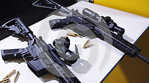 Tactical rifle with a colimator sight and some ammunition on the table