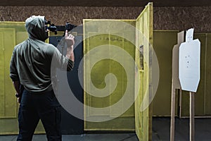 Tactical shooting from modern firearms at a shooting range. A man holds a carbine pistol in his hand