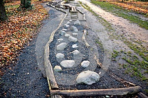 Tactile path for bare feet awakens the senses and uneven endings on the feet alternating different materials wood stone gravel san