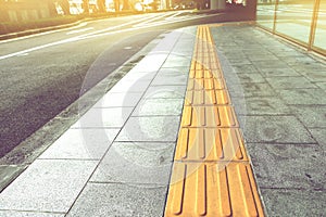 Tactile paving for blind handicap on tiles pathway. photo