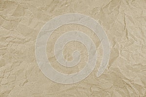 Tactile texture of crumpled beige paper. Wrinkled wrapping paper background. Packaging paper